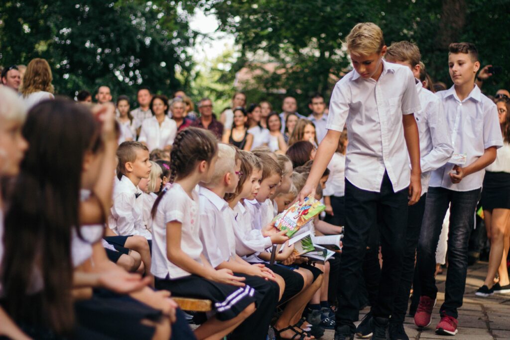 Children Receiving Bibles and Faith-based materials” “Children receiving illustrated Bibles during a faith-based community event”Alt Text: “Children receiving illustrated Bibles during a faith-based community event”